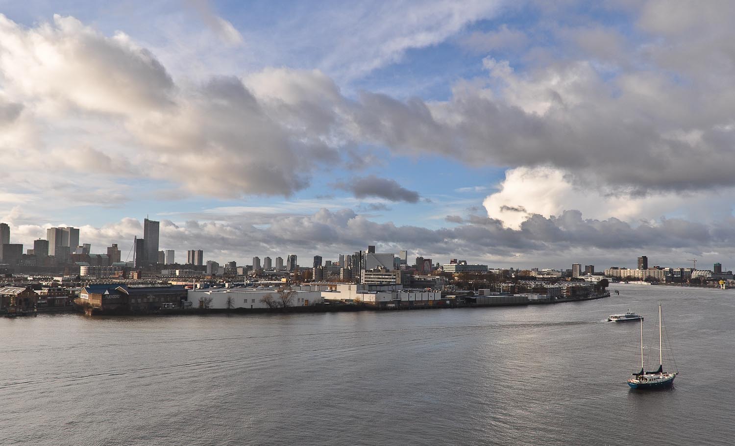 Skyline van Rotterdam met de Maas en een zeilboot, vastgelegd vanuit de lucht